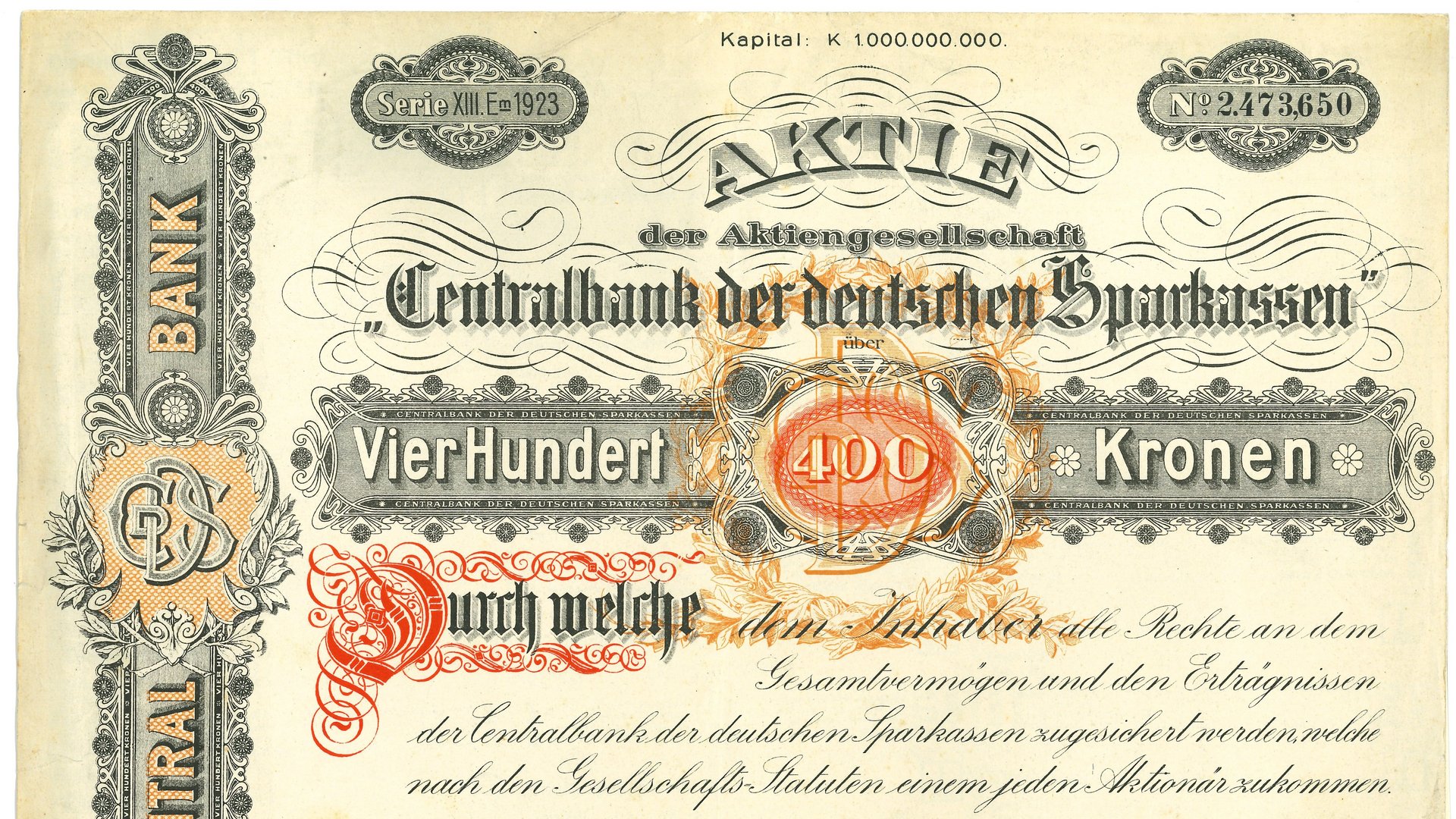 Historische Aktie der 'Centralbank der deutschen Sparkassen' aus dem Jahr 1923. Das Wertpapier ist auf 400 Kronen ausgestellt und enthält kunstvolle Verzierungen in Schwarz, Orange und Rot. Die Aktie trägt die Seriennummer 2473650 und zeigt offizielle Stempel und Unterschriften. In der Mitte des Dokuments ist der Betrag 'VierHundert Kronen' in großen Buchstaben hervorgehoben. Das Design umfasst klassische florale Muster und detaillierte Gravuren, die für alte Wertpapiere typisch sind.